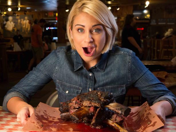 Host Courtney Rada with the beef ribs at Black's BBQ, as seen on Where's The Beef, Season 1.