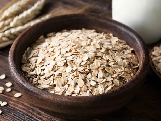 Rolled oats in wooden bowl on old wooden table. Rustic style. Healthy eating, healthy lifestyle, dieting and fitness menu concept