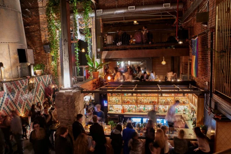 Through a nondescript door and down a flight of stairs, you’ll find an otherworldly bar locale — Old Glory is set in what used to be the boiler room of a clothing cleaner. It’s a dramatic entrance, especially with the tile-fronted chimney stack, and threads of climbing plants highlighting the high-ceilinged space. The offerings are just as cool. There’s a strong list of inventive signatures, like the Nature’s Call, an herbaceous blend of mezcal, parsley, celery, honey and yellow chartreuse, plus a classic beer list (think Modelo, Guinness and Oberon) and a tight selection of red, white and sparkling wines. To eat, it’s mainly snacks, like empanadas, which come out of the tiny kitchen space set beside the chimney.