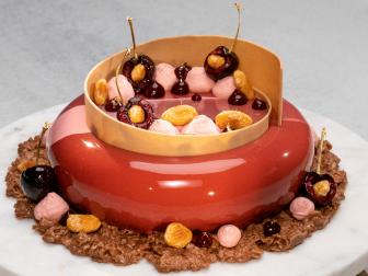 Contestant Joshua Livsey's dish is Almond and cherry Entremet with almond milk chocolate crunch, during the Master Challenge, as seen on Best Baker in America, Season 3.
