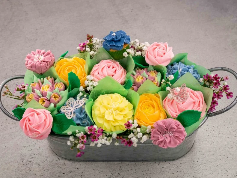 Contestant Sarah Throngnopneua's dish is Lemon cupcake with an almond American buttercream frosting (yellow cupcake liners), and Rose water cupcake with a rose water American buttercream frosting (green cupcake liners), during the final challenge, as seen on Cupcake Championship, Season 1.