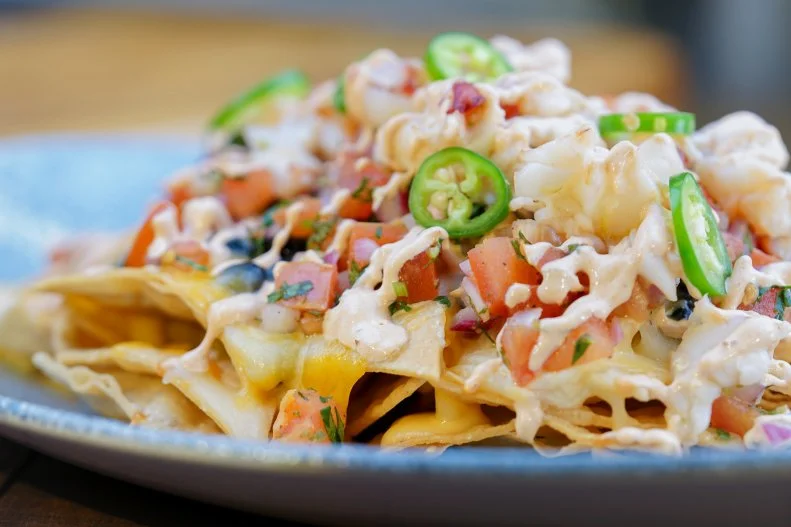 At Disney destinations, not even nachos are typical. Lamplight Lounge has developed a following for its lobster-topped nachos. This table-service gastropub with a cozy brick-and-concrete backdrop immediately became known for this dish since its 2018 opening in Pixar Pier. The setting is a tribute to all things Pixar. The nachos are a tribute to all thing irresistible — fresh lobster layered on chips with the usual black beans and cheese plus a chipotle crema and a buttery lobster cheese sauce made with house lobster stock. Whether choosing from the upstairs menu or the downstairs one (the lobster nachos are sold in both places), you can round out your meal with chile-ginger-glazed pork drumettes, Yukon potato skins with brown butter-caper yogurt and smoked paprika aioli, and tuna poke with spiced mango nectar.