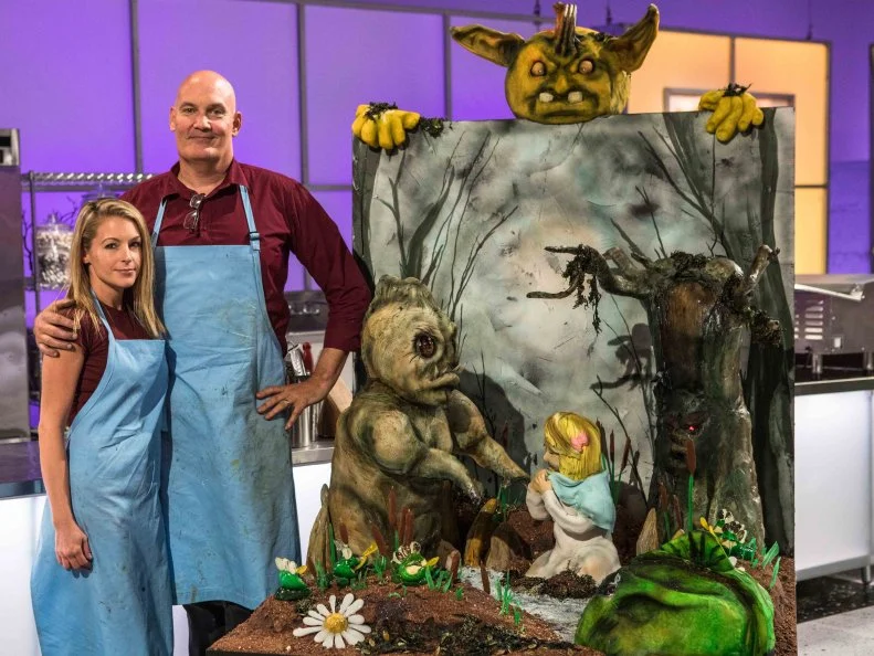 For the Spine Chiller Challenge, teams had 5-hours to create their version of being trapped in a nightmare; BUTTERCREAM BEASTS: Matt Harper (Pumpkin Carver), Beth Townsend (Cake Decorator), & Angela Sweetser (Sugar) were off to a rough start when Sugar sculptor Angela had to leave the competition for heath reasons, forcing Matt & Beth to put together their child trapped in a monster swamp on their own, as seen on Halloween Wars, Season 9.