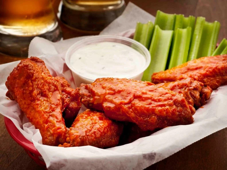 "Basket of hot wings with blue cheese dressing, celery sticks, and beers.  Please see my portfolio for other food and hot wing images."
