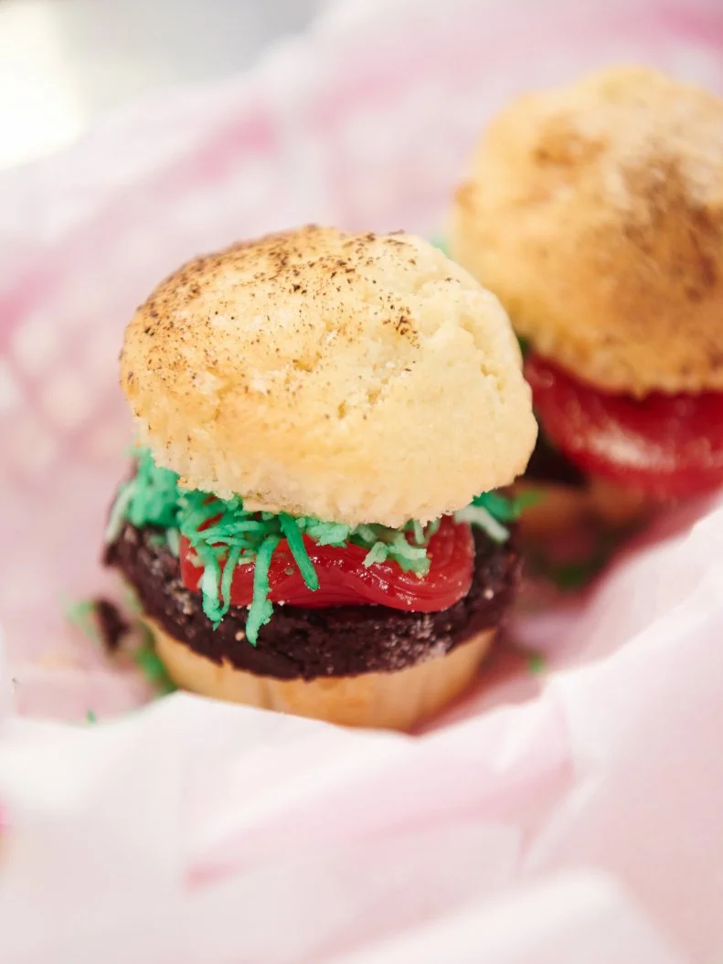 Contestant Natalie Venable's dish "Hamburger Sliders featuring brownie patties with a vanilla cupcake bun, 'thousand island' frosting, toasted coconut lettuce and a licorice tomato" for the challenge "Dessert Imposters" as seen on Food Network's Kids Baking Championship, Season 1.