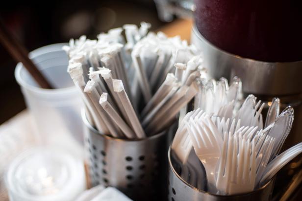 Plastic straws wrapped in paper and plastic forks are seen at a food hall in Washington DC on June 20, 2019. - "How do you drink a milkshake without a straw?" The city of Washington has decided, in the name of the environment, to ban plastic drinking straws -- an act viewed as almost sacrilegious in the birthplace of this simple but seemingly indispensable part of daily American life.In the last century, millions of straws were produced in the Stone Straw Building, a stolid-looking structure of yellowing brick in a residential neighborhood. The building now houses the capital's transit police headquarters. The only visible sign of its historic character comes from a discreet commemorative plaque affixed to a wall above a garbage bin that honors the memory of Marvin C. Stone, "Inventor of the Paper Straw." (Photo by Eric BARADAT / AFP)        (Photo credit should read ERIC BARADAT/AFP/Getty Images)