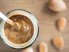 Almond Butter in jar with spoon, from directly above