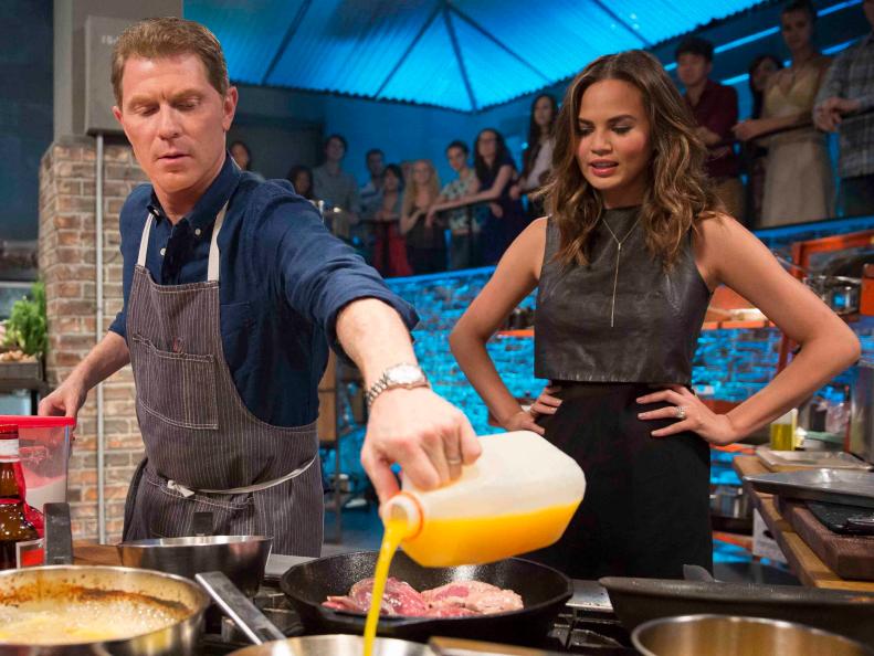 Bobby Flay cooks Duck L'Orange as Chrissy Teigen looks on as seen on Food Network's Beat Bobby Flay, Season 3
