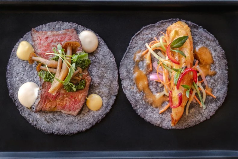 Surf and turf takes a taco form at Crujiente Tacos. A Texas Wagyu beef taco with soy-pickled shimeji mushrooms, fresh horseradish, Japanese mustard and cilantro “mojo” is served alongside the seared shrimp taco, with pickled vegetables, Thai green curry and basil. Both are served on blue corn tortillas.
