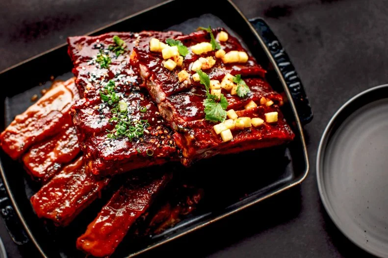 Chef Michael Mina and bestselling cookbook author Ayesha Curry join forces to bring International Smoke to life in Aventura, Florida. The menu, inspired by fire, grilling and smoke, consists of many noteworthy dishes, but St. Louis-style pork ribs are the real foundation of the menu. Each rack of ribs is crafted with an artisanal spice rub, smoked low and slow for several hours and finished with a unique sauce of choice. Guests can choose from interesting flavors like American BBQ, sesame-gochujang and garlic sweet and sour, to name a few.