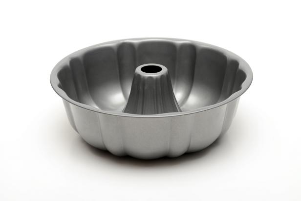 Close up of a bundt cake pan on a white background with shadows.