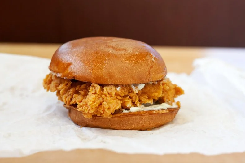 Possibly the most-hyped, most-discussed fried chicken sandwich in the world, Popeyes’ rendition caused an internet frenzy when it debuted in August 2019. Some customers reported waiting over an hour to get a taste. The chain sold out of the sandwich in weeks. And a man was stabbed to death at one location after a fight broke out. Why the mayhem? The tender chicken breast fillet is marinated in the chain’s classic blend of Louisiana seasonings, hand-battered and breaded in a buttermilk coating that crunches loudly when you sink your teeth into it. It’s served on a warm toasted brioche bun with crisp barrel-cured pickles and a choice of classic or spicy mayonnaise. Order on the Popeyes App to skip the crazy wait.