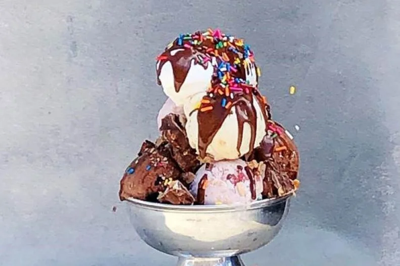 This downtown Nashville complex offers a wide-ranging menu of fun activities, from axe throwing to rooftop cocktails. Its main restaurant, The Ribbon Room, serves up American classics, including a candy shop-inspired sundae. Three classic scoops — chocolate, vanilla and strawberry — are topped with caramel, hot fudge, whipped cream, toffee bits, peanut butter cups, crushed Oreos and rainbow sprinkles for a scrumptious flashback sundae.