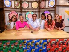 Host Alyson Hannigan with judges Katie Lee, Nacho Aguirre, and Carla Hall, and Girl Scouts Persya Perez and Bryana Turner, as seen on Girl Scout Cookie Championship, Season 1.