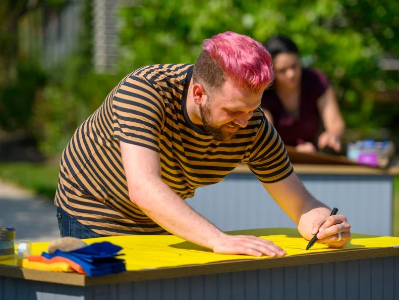Competitor Kyle Smothers prepares his booth for the space inspired cookie pops tasting and judging, as seen on Girl Scout Cookie Championship, Season 1.