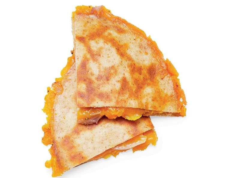 Toss 2 cups diced butternut squash and 1 sliced small red onion with 2 teaspoons olive oil on a baking sheet; season with salt and pepper. Roast at 425˚ until browned, 30 minutes. Divide between 2 whole-wheat tortillas; mash with a fork. Top each with 1/3 cup shredded extra-sharp cheddar and another tortilla. Cook each quesadilla in an oiled skillet over medium-high heat, flipping once, until crisp and brown, 2 to 3 minutes.