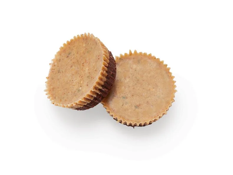 Microwave 3 ounces finely chopped bittersweet chocolate with 2 tablespoons heavy cream until just melted, 20 to 30 seconds. Stir until smooth. Divide among 12 lined mini-muffin cups; gently tap the pan against the counter. Freeze until firm, 10 minutes. Mix 3 tablespoons almond butter, 2 tablespoons hemp hearts, 1 tablespoon coconut sugar, 2 teaspoons melted coconut oil and 2 pinches of salt. Divide among the muffin cups and freeze until ready to eat, at least 1 hour.