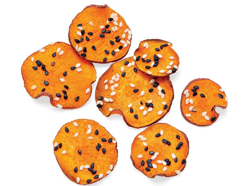 Slice 1 small sweet potato into very thin rounds (preferably on a mandoline). Coat 2 baking sheets with cooking spray, then divide the sweet potato slices between the pans in a single layer. Coat with cooking spray and sprinkle with sesame seeds. Bake at 350˚ until crisp and dry, 15 to 25 minutes. Season with salt.