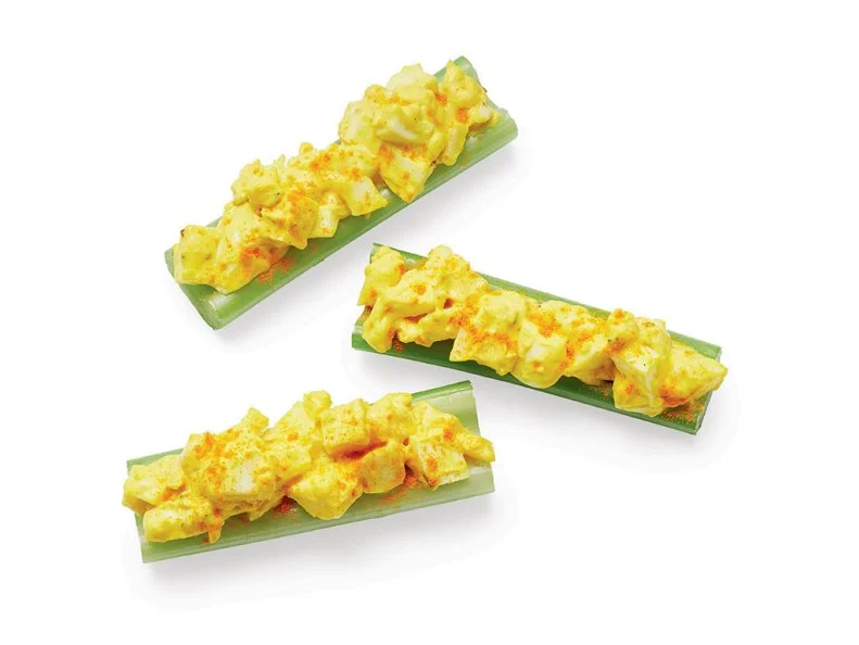 Mix 4 chopped hard-boiled eggs with 4 teaspoons yellow mustard, 1 tablespoon mayonnaise, 1 teaspoon olive oil and a pinch of ground turmeric; season with salt and pepper. Spoon into celery sticks.