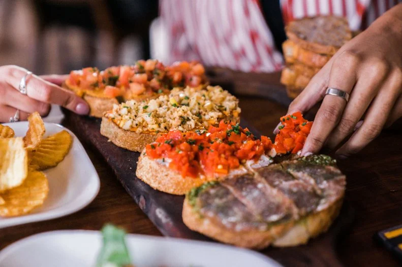 <a target="_blank" href="https://www.postinowinecafe.com/">Postino</a> is a welcoming wine bar with an all-day happy hour and a customizable bruschetta board menu. The idea that launched in an old Arcadia post office in 2001 has now expanded to 10 locations (including 4 in Texas and Colorado), including an especially excellent one at Scottsdale Road and Highland, in an old Valley National Bank branch. The mid-century modern space pays homage to the original architect, Frank Lloyd Wright apprentice Frank Henry, while you pay homage to a $5 glass of bubbles and smoked-salmon bruschetta. 