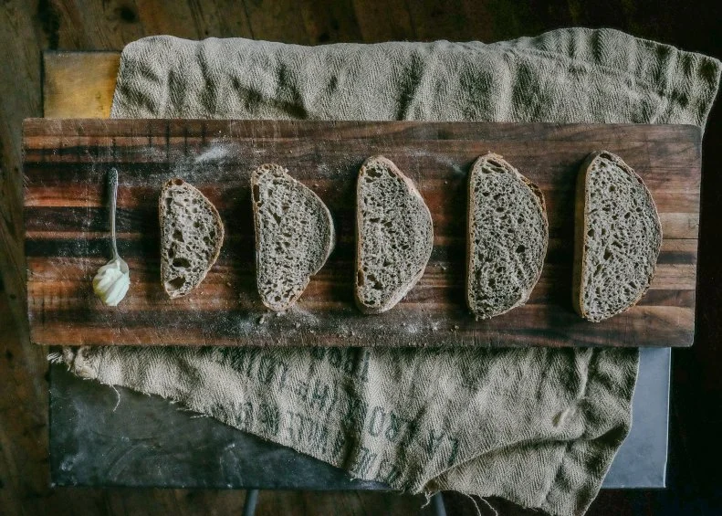 Noah Elbers grew up in a creative and resourceful family; they could build everything from a cider press to a bread oven. So, it’s not surprising that he became an entrepreneur himself, opening <a target="_blank" href="http://www.orchardhillbreadworks.com/">Orchard Hill Breadworks</a> in the rural town of East Alstead when he was 20 years old. The bakery takes its name from Orchard Hill Farm, which his grandfather and father built in 1972 as a small, U-pick organic apple orchard and cider press. The Breadworks portion of the name reflects Elbers’ dedication to craft and his work ethic. Orchard Hill offers a spectrum of loaves, ranging from a dense, 100% whole grain rye to a light-and-airy challah-style sandwich bread. You can find the breads at local food co-ops, restaurants and farm stands, though the bakery also counts a loyal customer base, including folks who have been buying a loaf a week for 20 years. Many families make Saturday morning pastries a part of their weekend ritual, too. Fan favorites from the pastry case include seasonal danishes, toasted granola cookies and double-dark-chocolate cookies. Orchard Hill is truly a community-supported bakery; thanks to a successful crowdfunding campaign, Elbers will be able to purchase a New American Stone Mill in order to mill flours fresh on-site.