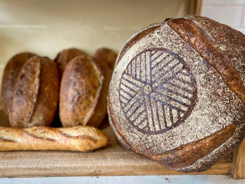 Since its founding in 1993, <a target="_blank" href="http://www.madisonsourdough.com/">Madison Sourdough</a> has changed owners and moved a few times, but in 2010, employee Andrew Hutchison bought the business and returned the beloved bakery to its original Williamson Street (aka Willy Street) location in Madison’s WilMar neighborhood. Over the years, Hutchison has doubled down on his commitment to Wisconsin-grown grains and in 2015, brought the milling operation in-house. The stone-milled flours are used within 48 hours to harness the fresh flours’ essential oil and wheat germ content, which impart intense flavors and aromas. Hutchison recommends trying the miche, a mixed grain featuring a blend of bread flour, wheat flour and coarsely ground rye flour that gives the loaf its earthy, malty flavor profile. Because of its size (it clocks in at five pounds!), it develops an intensely caramelized crust which contrasts nicely with a sticky, chewy and plentiful crumb. It’s quickly become a staple for locals who buy a half or whole loaf for the week. Snag a table in the café and tuck into one of the miche-based tartines, or sop up a saucy shakshuka with a piece of grilled sourdough. 