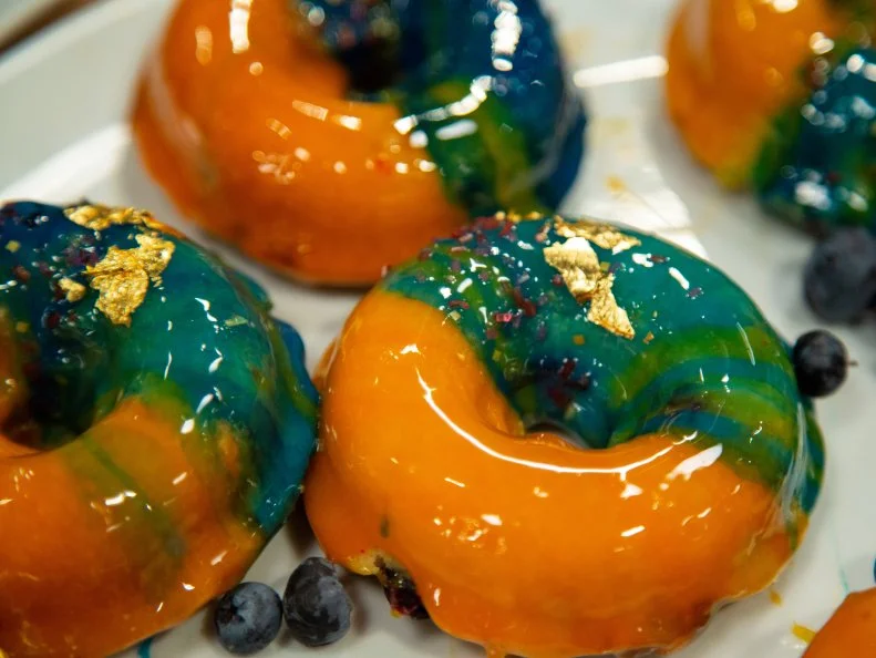 Sandra's final preheat dish - SANDRA: Sunset. Coconut Blueberry Doughnut with Pecan Caramel Crunch, as seen on Spring Baking Championship, Season 6.