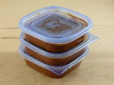Batch of freshly made spaghetti sauce with ground turkey meat in plastic storage containers to prepare for freezer and meals in advance for work week
