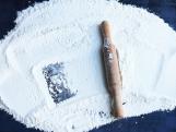 Rolling pin and white flour on a dark background. Free space for text. Top view.