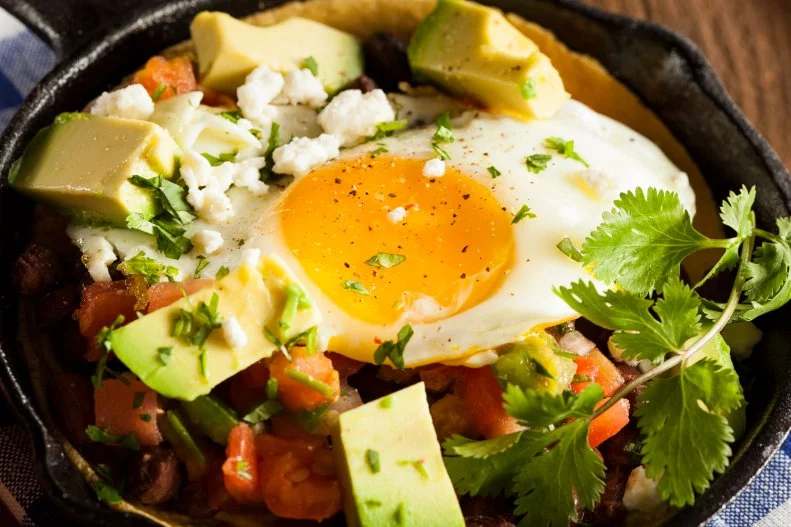 Rebecca Clyde MS, RDN, CD cooking for one expert, and owner of <a target="_blank" href="https://nourishnutritionblog.com/">Nourish Nutrition Blog</a> has been eating a variation of huevos rancheros made which includes a dry pan fried tortilla, smashed black beans, a sprinkle of cheddar cheese, a fried egg, and my favorite salsa. “I like this easy dish because it takes less than 10 minutes to throw together and I always have all the basic ingredients on hand (eggs, canned beans, tortilla, cheese, salsa). Clyde explains that this lunch is especially great right now because you can raid your fridge and add whatever other veggies you have on hand such as cabbage, zucchini, corn, lettuce, onion, or anything else you'd like to add. “This lunch is full of different flavors, textures, and excitement to get you to look forward to taking a short break for lunch.”