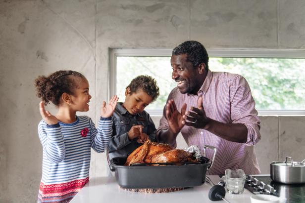 Fathers preparing thanksgiving turkey with his kids