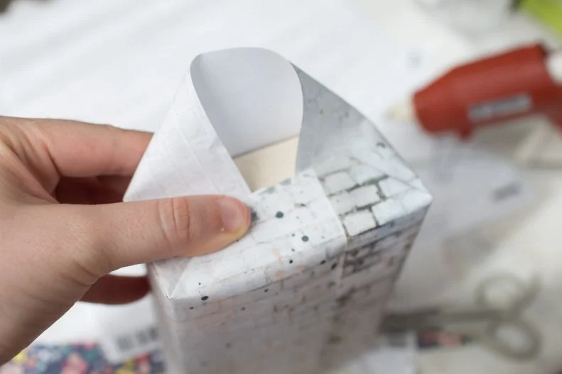 Using whatever color or textured of scrapbook paper you like (we used different brick patterns), wrap the boxes like you’d wrap a present. Kids might need a little help with this. If you prefer not to see the tape, adults can use hot glue to seal the edges. 