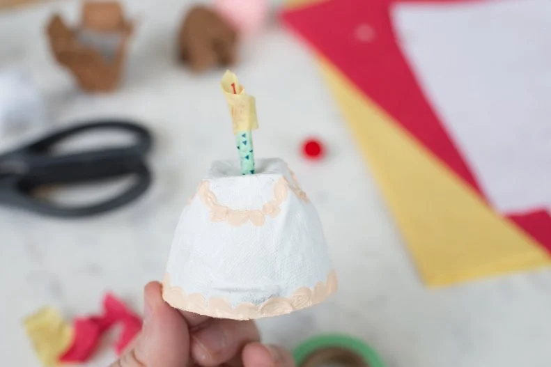 Punch the skewer into the top of your egg carton cake to make a candle-topped cake. 