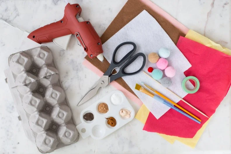 Egg carton
Paint
Paintbrushes
Large pom-poms
Small pom-pom
Felt
Hot glue
Scissors
Toothpick
Tissue paper
Washi tape
Cardboard
Aluminum foil
