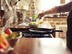 cooking vegetables in real, rustic kitchen. Natural light, short DOF, a little bit noisy.