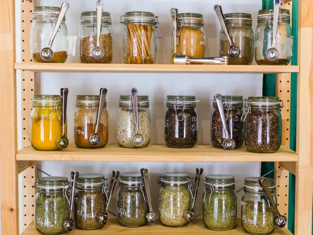 Close up of shelves with a selection of spices and grains in glass jars in zero waste shop
