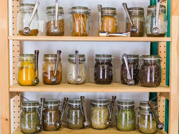 Close up of shelves with a selection of spices and grains in glass jars in zero waste shop