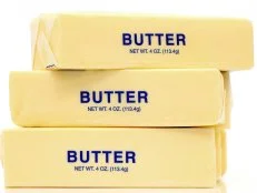 Traditional wrapped butter sticks on white background