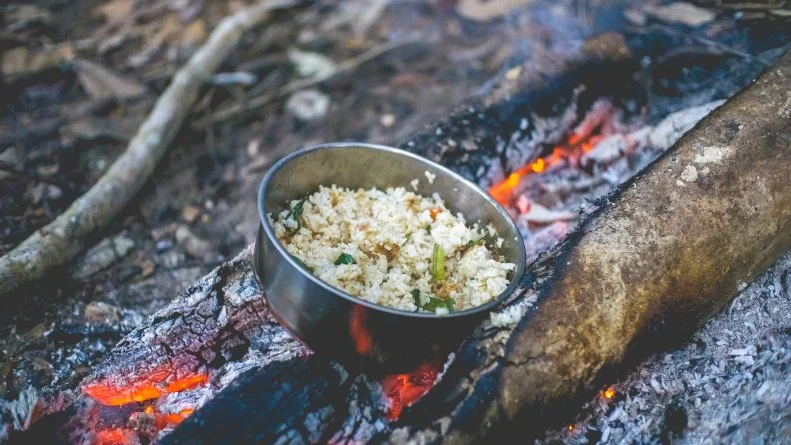 These meals have come a long way since being heavily used in the military years ago. Use your heat source to warm up water and add it to your meal. <a target="_blank" href="https://goodto-go.com/">Good To-Go</a> and <a target="_blank" href="https://backpackerspantry.com/">Backpackers Pantry</a> sell lightweight meals for campers where all you need to do is add water. You can also use the hot water to make tea, coffee, pasta or rice.
