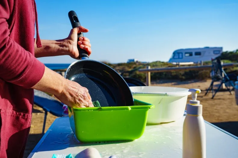 One of the most important ways to keep you and your family safe when camping is to wash your hands before and after handling food. Both soap and water are needed to wash your hands. If you are going somewhere that will not have running water, bring it with you. 
If you’re camping for several days, the dishes and pots will need to be washed properly. Bring disposable wipes or biodegradable soap for hand washing and dishwashing.
