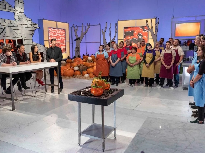 Team Mummies Rejects faces the judges, Left to Right: Guest judge Jeremy Ray Taylor, judges Todd Tucker and Shinmin Li, and host Jonathan Bennett during Episode 1 Small Scare challenge "It Came From the Pumpkin Patch…." as seen on Halloween Wars, Season 10.