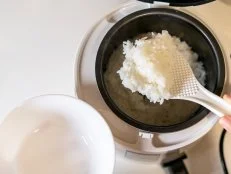 spooning rice from electric cooker