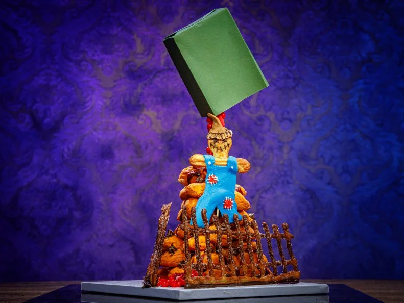 Contestant Michelle Lee's CINNAMON CANDY/SCARECROW CROQUEMBOUCHE FILLED W/ PUMPKIN PASTRY CREAM AND APPLE BUTTER, PATE A CHOUX FENCE, as seen on Halloween Baking Championship, Season 6.