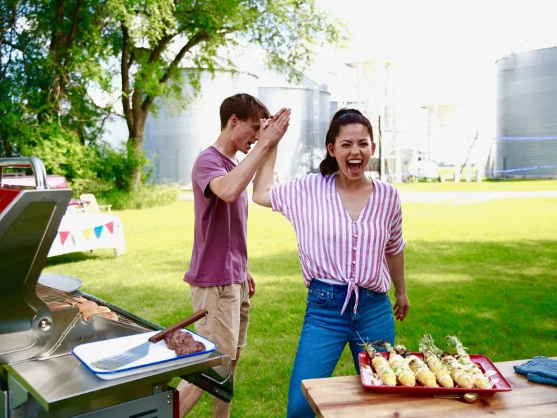 Molly and Nick candidly high five together after finishing the grilling for their dinner with friends. , as seen on Girl Meets Farm, Season 4.