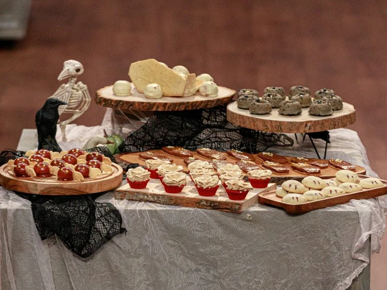 Contestant Michelle Lee’s.BANANA MOUSSE BATS W/ MACADAMIA NUT SHORTBREAD AND CHOCOLATE GLAZE, .BLACK SESAME AND BLACK GARLIC FINANCIER, .GRAHAM CRACKER COFFINS, CHOCOLATE HAZELNUT CRUNCH.with Sinai Vespie’s.RED VELVET ROSE BITES W/ COOKIE BUTTER BUTTERCREAM, .WHITE CHOCOLATE COVERED CHERRY CHEESECAKE GHOSTS, .ROSEMARY AND TOASTED SESAME SEED SHORTBREAD W/ BLACK GARLIC JAM, .COFFIN TWIST: SHORTBREAD, .Round 3, Vampire Buffet, as seen on Halloween Baking Championship, Season 6.