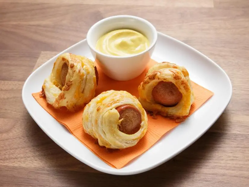 The blue team's Cheese Mummy Dogs are displayed, as seen on Worst Cooks in America Halloween Special.