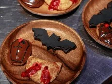 Tamara Brown’s .NUTTY BLACK BROWNIE BAT,.BLOODY BERRY HAND PIE VAMPIRE’S BITE,.BLACK GARLIC CITRUS MADELEINE COFFIN, .COFFIN TWIST: SABLE DOUGH,.Round 3, Vampire Buffet, as seen on Halloween Baking Championship, Season 6.