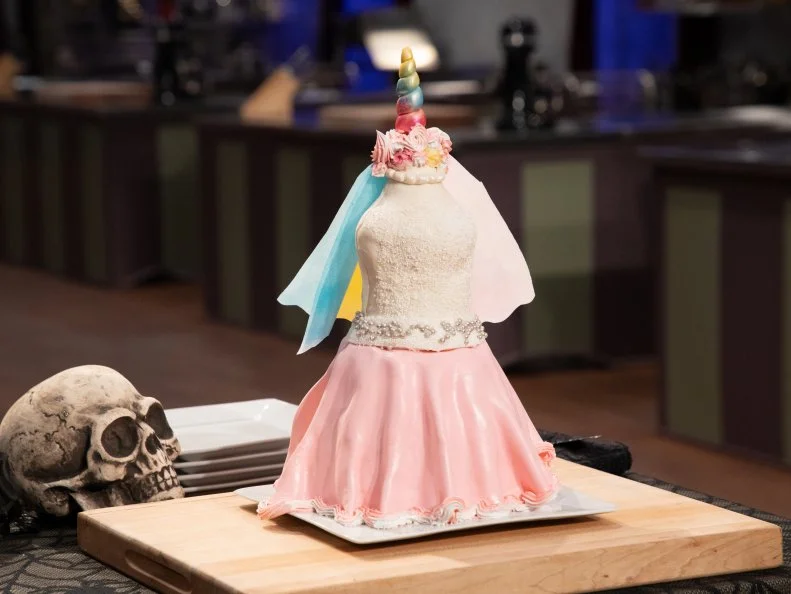Renee's cake on tasting podium - VANILLA RUM CAKE W/ LEMON CURD, RASPBERRY FILLING AND SWISS MERINGUE BUTTERCREAM. .EDIBLE JEWELRY: FONDANT PEARL NECKLACE, as seen on Halloween Baking Championship, Season 6.