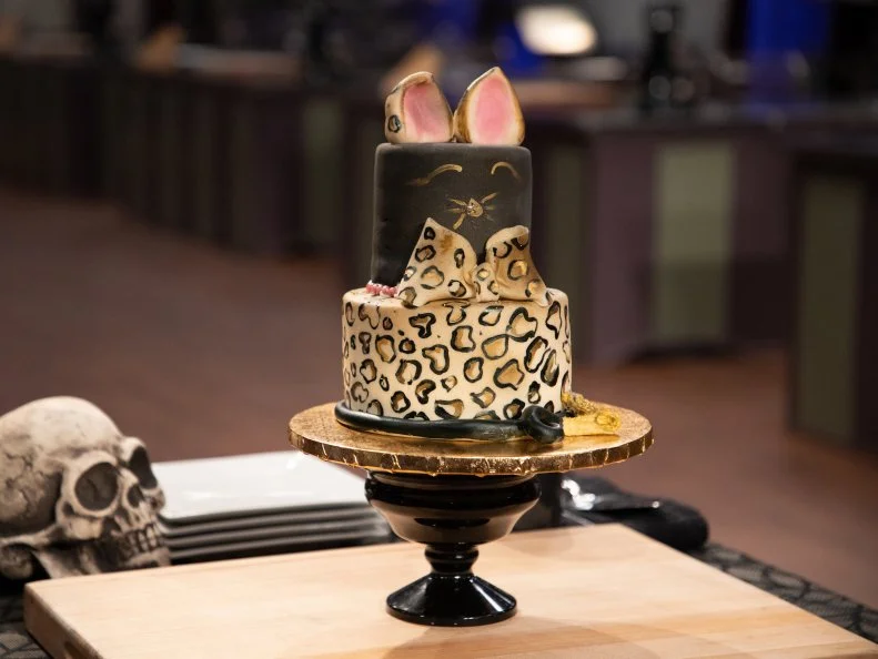 Sinai's cake on tasting podium - VANILLA BEAN CAKE W/ PEACH CHERRY RUM FILLING AND SWISS MERINGUE BUTTERCREAM. .EDIBLE JEWELRY: PINK CHOCOLATE CANDY CHOKER, as seen on Halloween Baking Championship, Season 6.