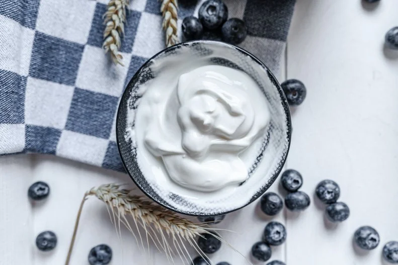 Greek yogurt is filled with protein, about 15 grams per 6 ounce serving of nonfat plain. As protein takes longer to digest, Greek yogurt can help you feel fuller longer. Feeling full and satisfied is especially important when you are trying to lose weight., since it can help minimize those extra snack cravings.
In addition, a <a target="_blank" href="https://pubmed.ncbi.nlm.nih.gov/15672113/">study</a> published in the International Journal of Obesity found that people who were obese who ate yogurt daily over the course of three months lost more body fat while maintaining lean tissue compared to those who did not eat yogurt daily. Those eating yogurt also lost more inches around their waist.
